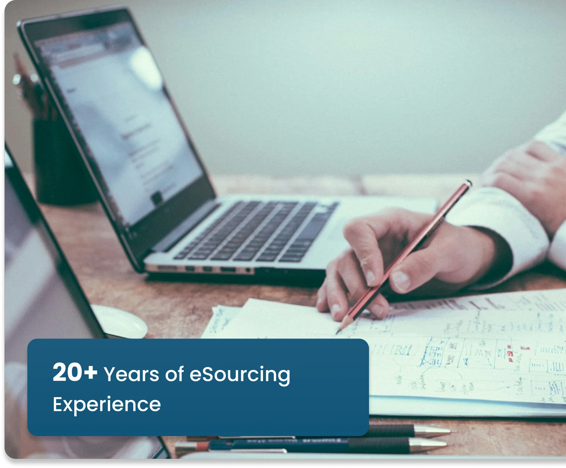 Professional working on a laptop with a note reading 20+ years of eSourcing experience